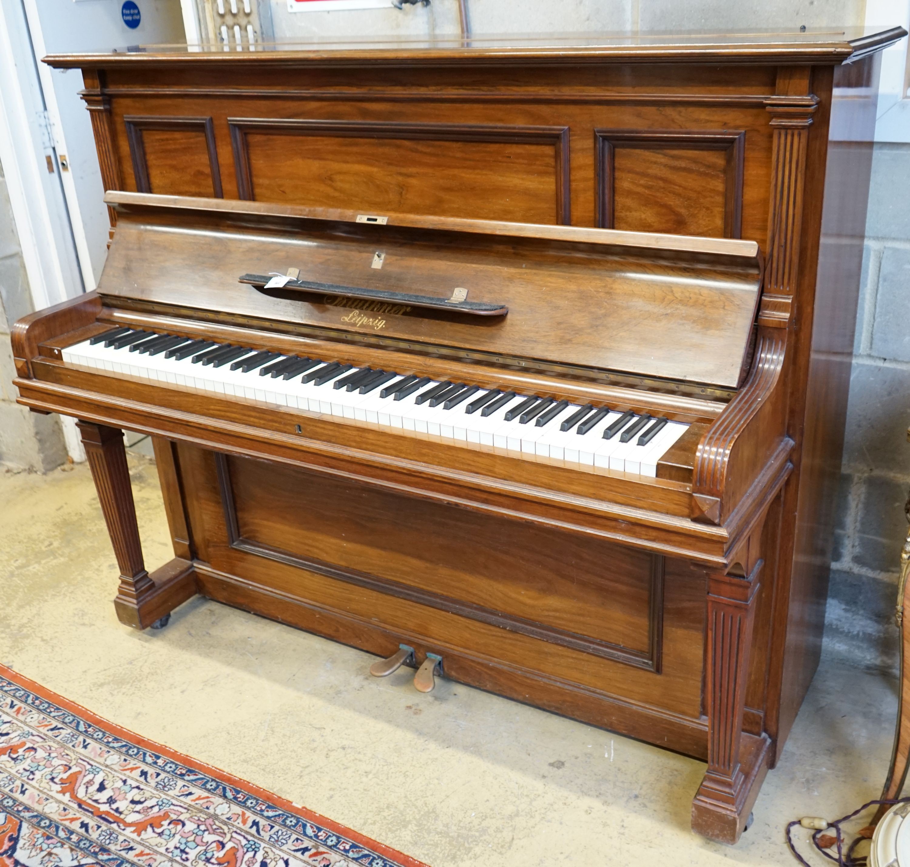 An early 20th century walnut cased Bluthner upright piano, Serial Number 92280